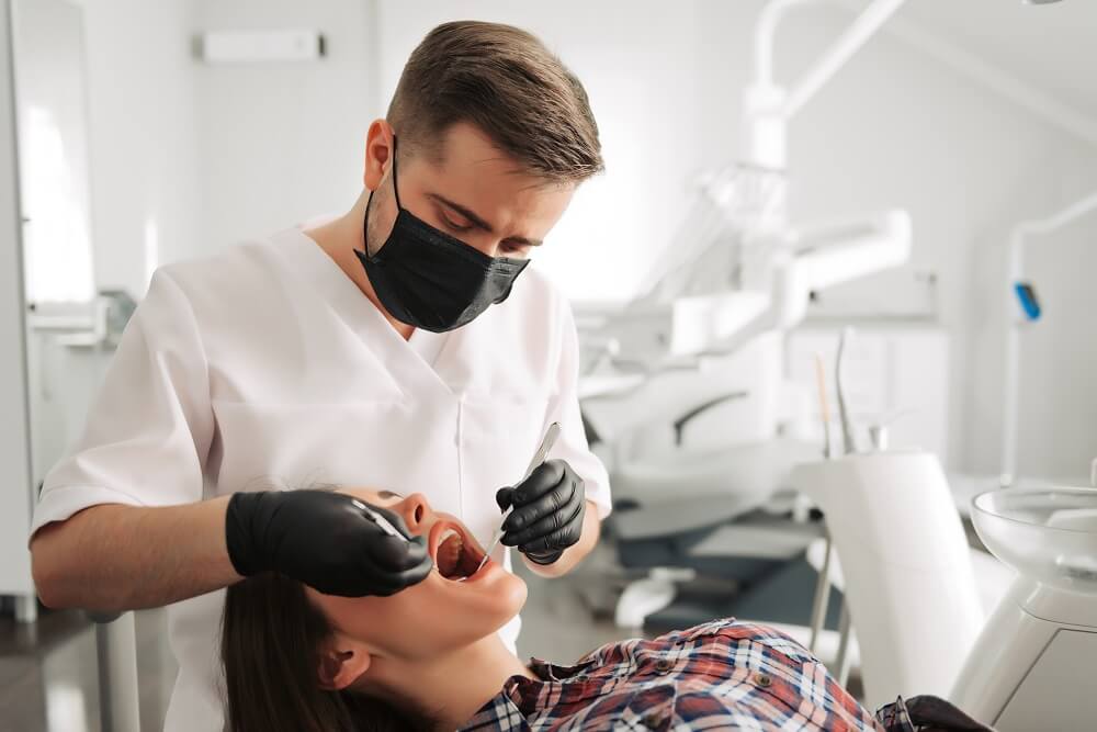 Dentista realizando procedimento em paciente