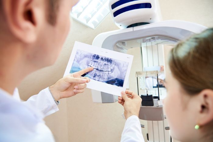 dentista mostrando raio-x para a paciente