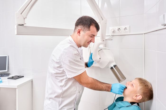 dentista tirando raio x de paciente infantil