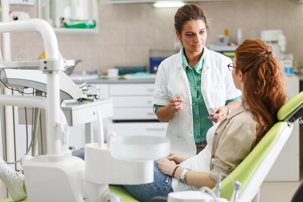 Dentista conversando com paciente.