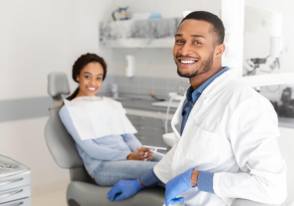 Dentista sorrindo em consultório odontológico