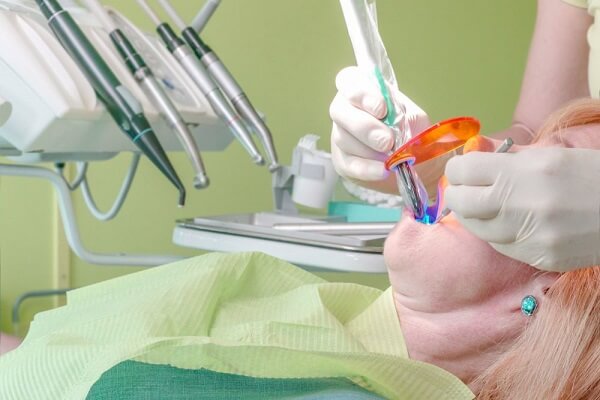 dentista utilizando fotopolimerizador para restauração