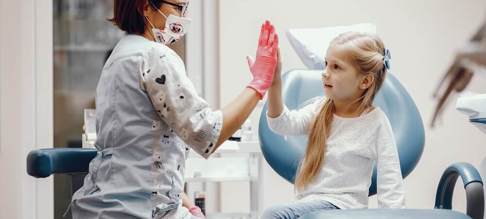 Dentista e criança se cumprimentando