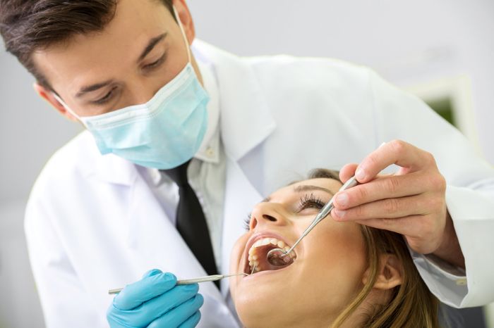 dentista aplicando práticas de ergonomia odontologia