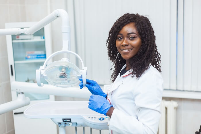 Mulher negra dentista em consultório odontológico