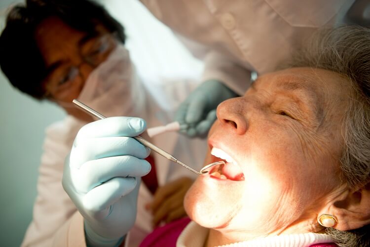 Idosa recebendo tratamento odontológico
