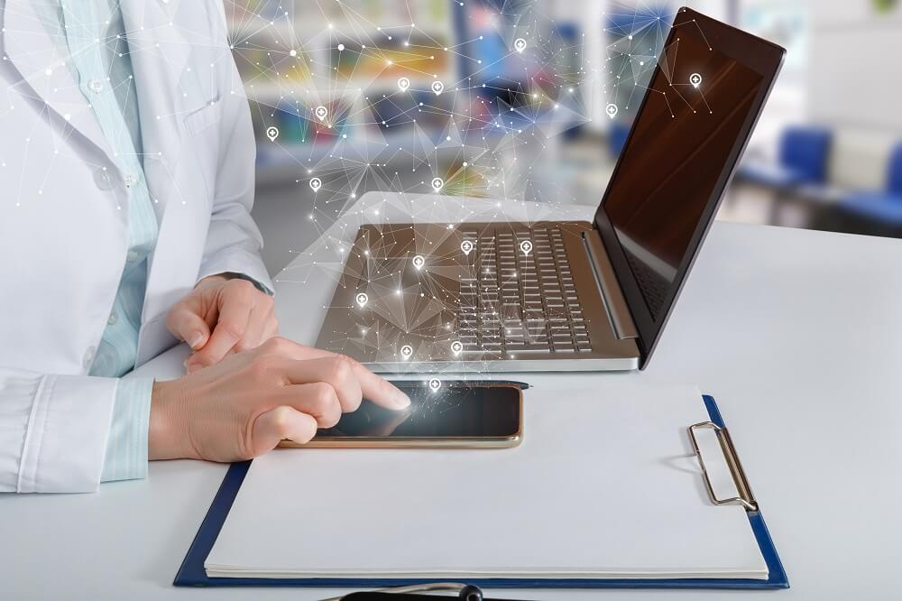 Notebook com ícones de segurança e mão mexendo em celular