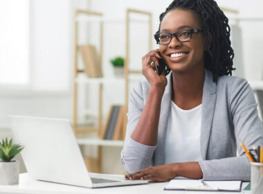 Mulher negra, recepcionista, fazendo confirmação de consulta ao telefone