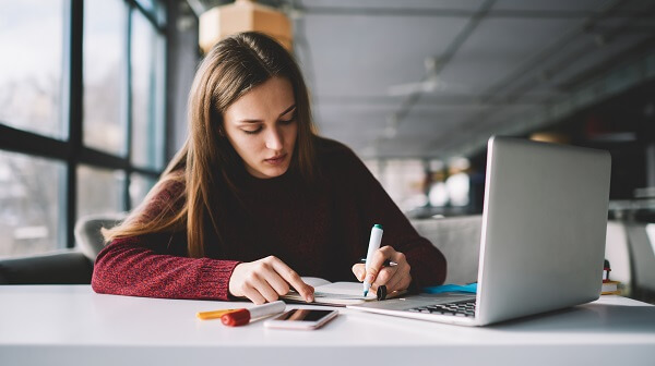 Estudante na biblioteca estudando história da odontologia.