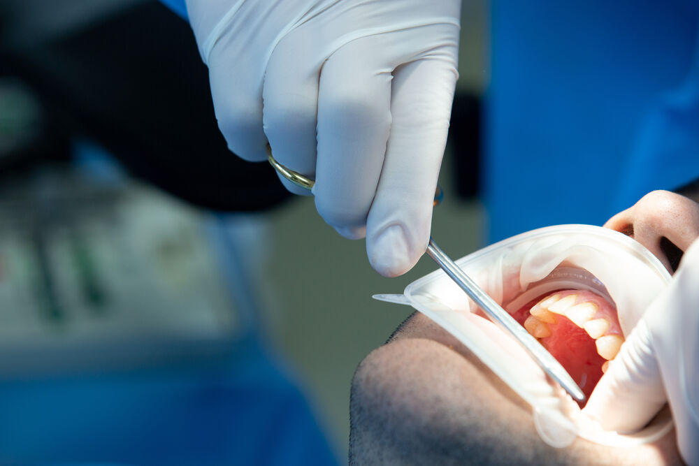 Profissional de odontologia examinando dentes de paciente