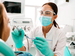 dentista em atendimento a uma paciente do gênero feminino utilizando aparelhos que passaram por manutenção de equipamentos odontológicos
