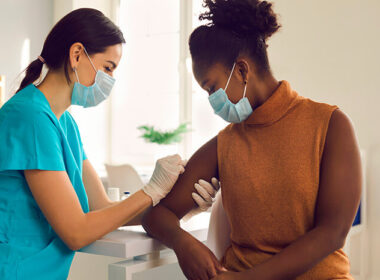 mulher aplicando vacinas para dentistas em uma profissional do gênero feminino