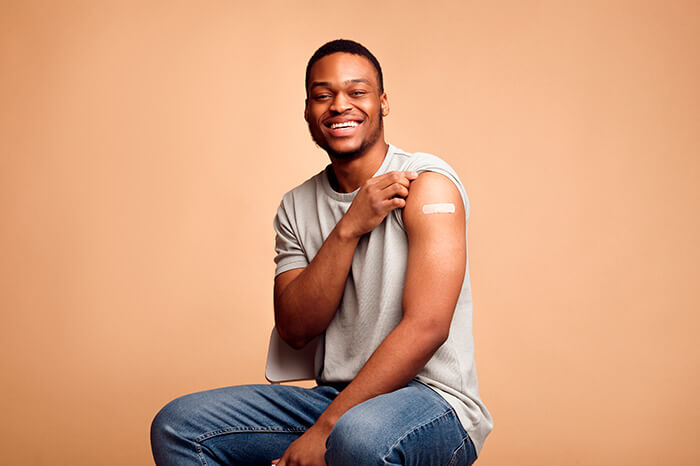 homem negro mostrando o braço, no local que recebeu uma das vacinas para dentistas