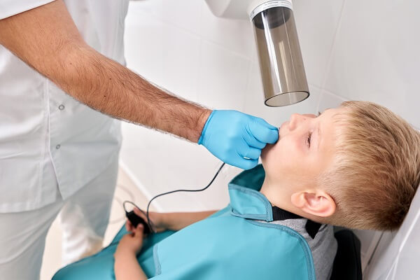 Menino com sensor intraoral na boca.