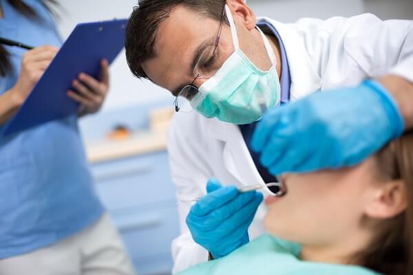 Dentista fazendo atendimento odontológico