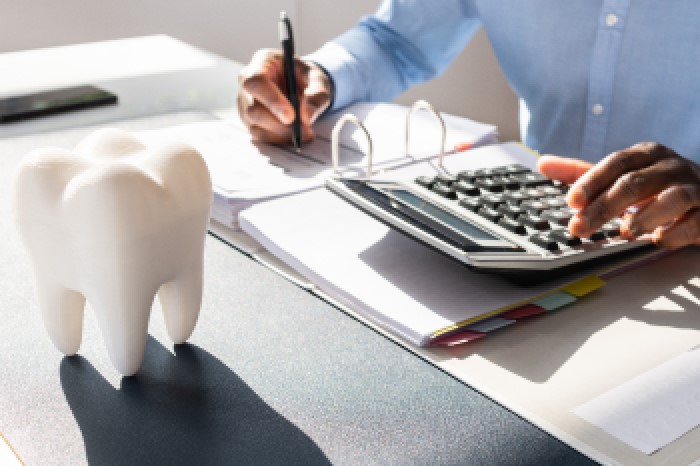 Dentista fazendo anotações no seu consultório.