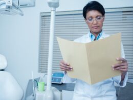 Dentista realizando análise de exames laboratoriais.
