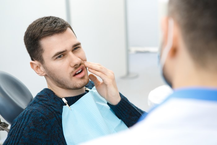 Dentista realiza tratamento de canal em paciente com pulpite.