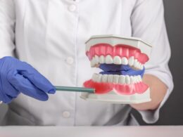 Dentista mostra pulpite em manequim odontológico.