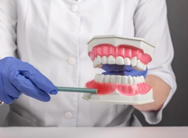 Dentista mostra pulpite em manequim odontológico.