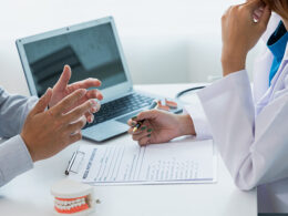 duas pessoas em uma sala uma dentista e um paciente
