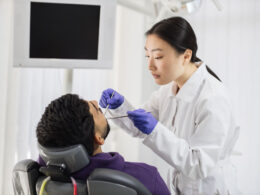 Dentista realizando exame em paciente na clínica dental