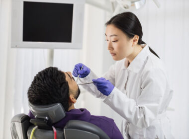 Dentista realizando exame em paciente na clínica dental
