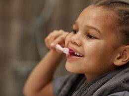 Criança escovando os dentes sorrindo