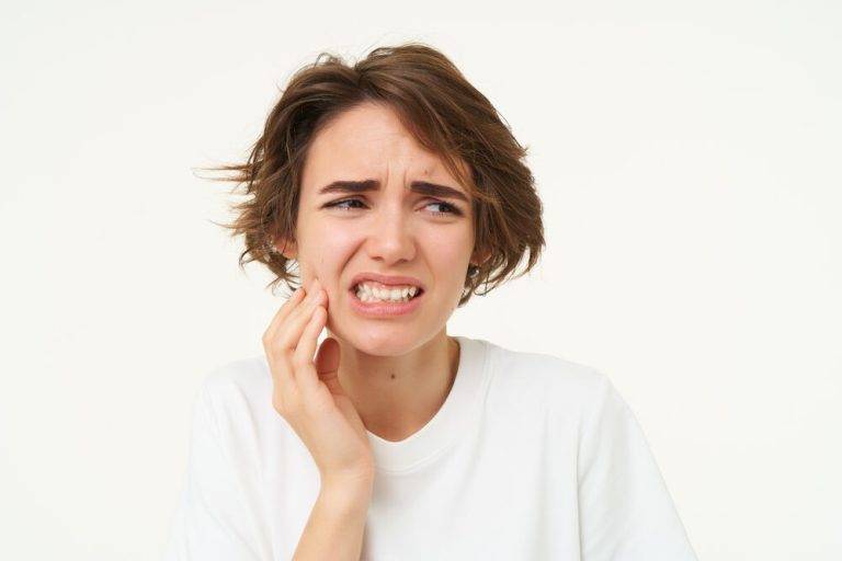 Jovem com dor de dente e expressão de desconforto