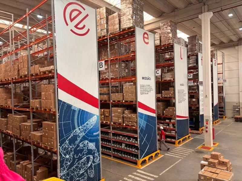 Armazém com prateleiras cheias de caixas empilhadas.