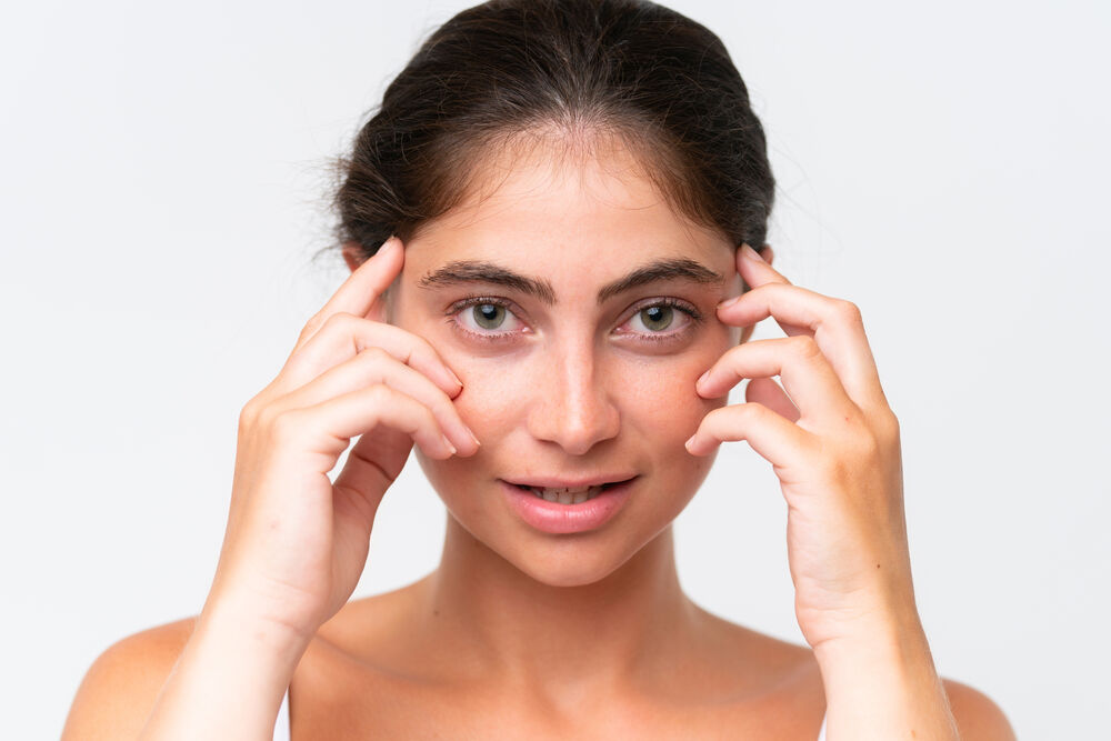 Mulher com expressão suave tocando o rosto